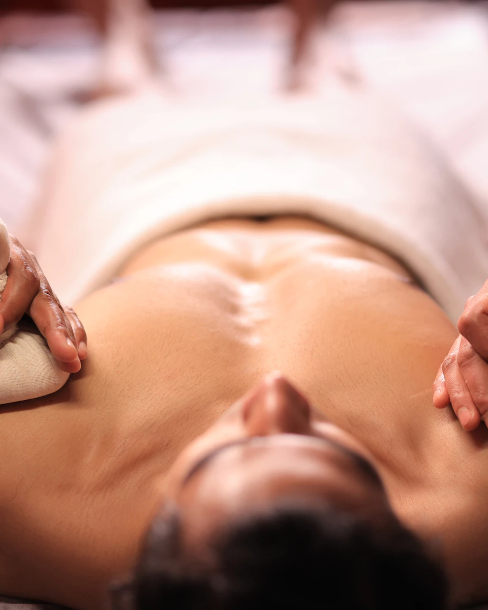 A guest receiving a warm herbal spa treatment